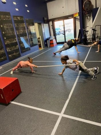 crossfit kids fitness class playing balance and core strength game